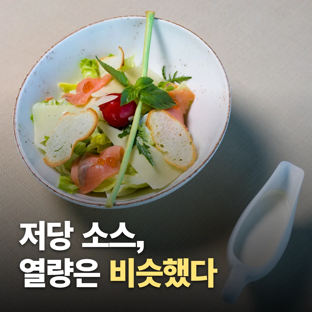식당 식탁의 샐러드와 따로 담긴 드레싱 실사 위에 ‘저당 소스, 열량은 비슷했다’라고 쓴 썸네일. 그림이 아니다.
